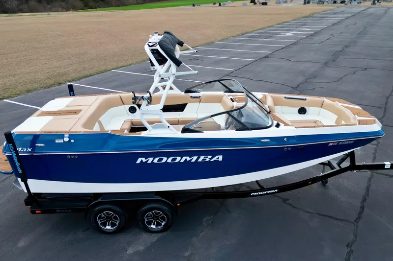 Slide: The Image of 2024 Moomba Max boat in blue and white on a trailer, parked in a lot. - 4