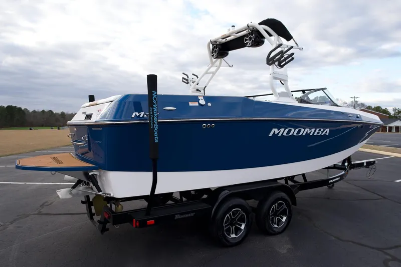 Slide: The Image of 2024 Moomba Max boat in blue, parked on a trailer, showcasing sleek design. - 5