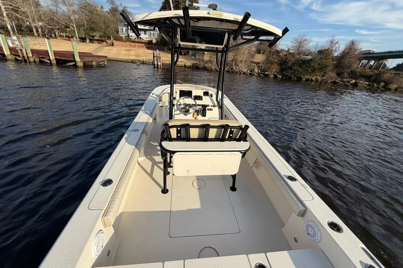 Slide: The Image of 2018 Carolina Skiff 24 Ultra Elite boat on calm water, featuring spacious deck and seating. - 10