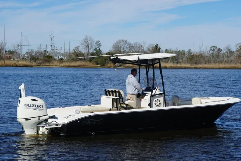Slide: The Image of 2018 Carolina Skiff 24 Ultra Elite boat with Suzuki engine on a calm river. - 11