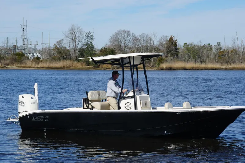 Slide: The Image of 2018 Carolina Skiff 24 Ultra Elite boat cruising on a calm river. - 13