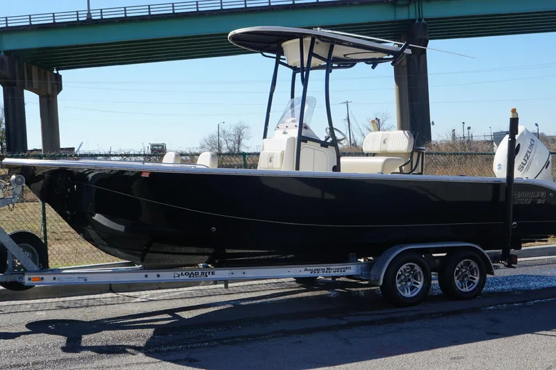 Slide: The Image of 2018 Carolina Skiff 24 Ultra Elite boat on trailer under bridge. - 4