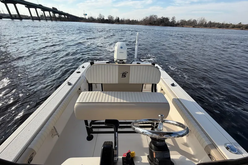Slide: The Image of 2018 Carolina Skiff 24 Ultra Elite boat on water, bridge in background. - 7