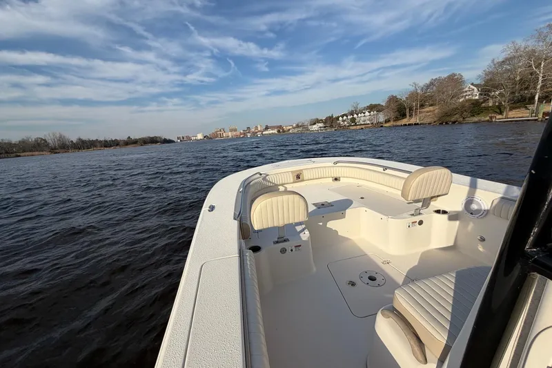 Slide: The Image of 2018 Carolina Skiff 24 Ultra Elite boat on calm water under a blue sky. - 8