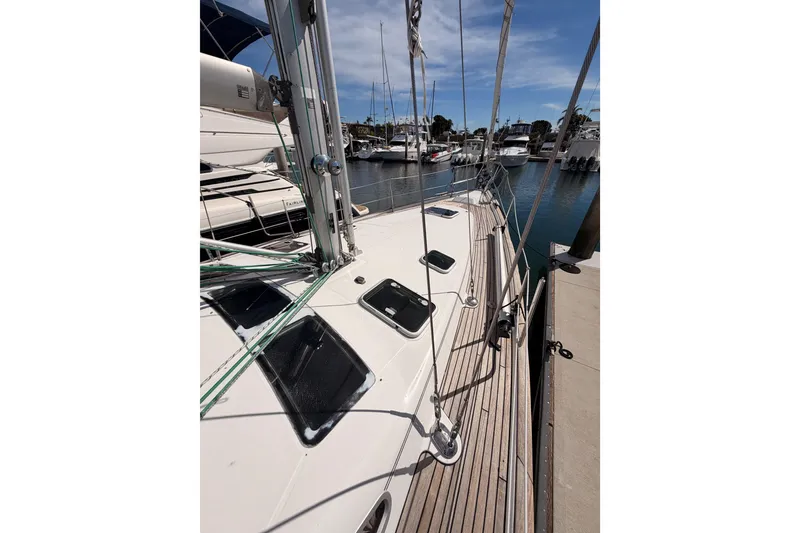 Slide: The Image of 2005 Beneteau Oceanis Clipper 423 sailboat docked in a marina under clear skies. - 19