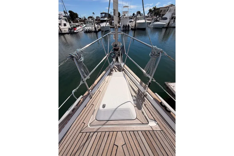 Slide: The Image of 2005 Beneteau Oceanis Clipper 423 sailboat deck in marina, showcasing teak wood finish. - 22