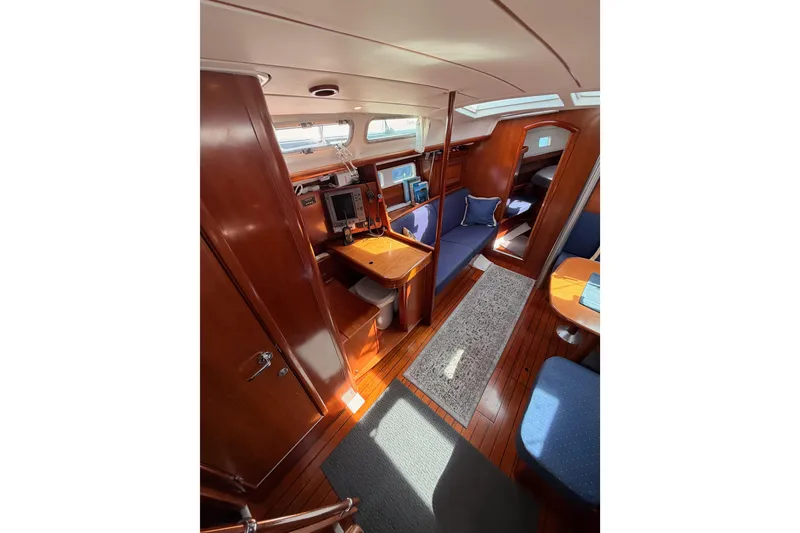 Slide: The Image of Interior of 2005 Beneteau Oceanis Clipper 423 yacht, featuring wood finishes and cozy seating. - 38