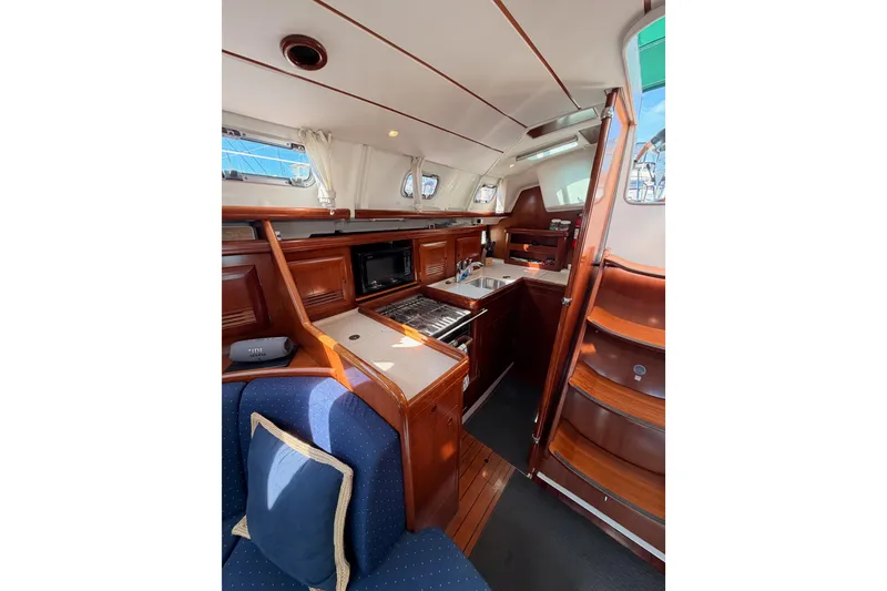 Slide: The Image of Interior of 2005 Beneteau Oceanis Clipper 423 yacht, featuring a cozy kitchen and seating area. - 39