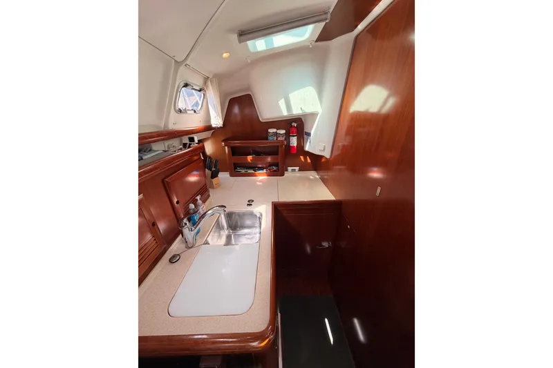 Slide: The Image of Interior of 2005 Beneteau Oceanis Clipper 423 yacht, featuring a compact kitchen area. - 40