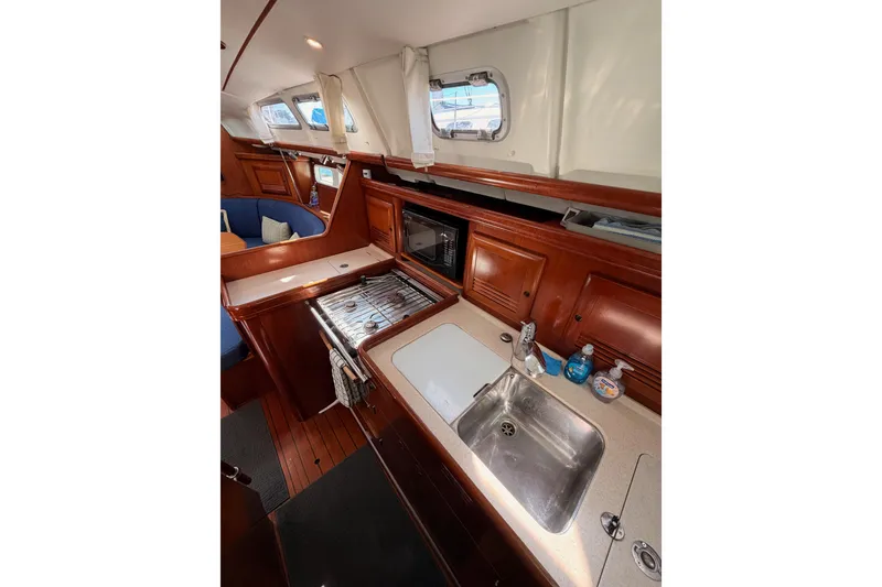 Slide: The Image of Interior of 2005 Beneteau Oceanis Clipper 423 yacht, featuring a well-equipped galley kitchen. - 43