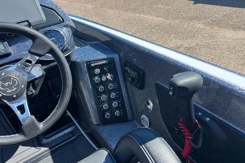 Slide: The Image of 2026 Phoenix 21 XE boat dashboard with steering wheel and control panel. - 12