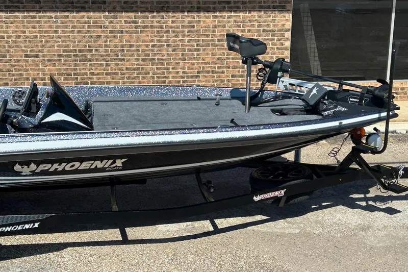 Slide: The Image of 2026 Phoenix 21 XE boat on trailer, sleek design, parked by brick wall. - 3