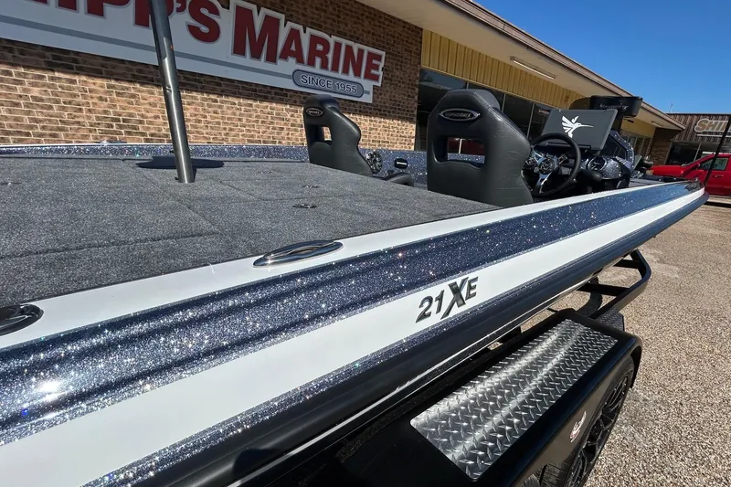 Slide: The Image of 2026 Phoenix 21 XE boat at dealership, showcasing sleek design and glittering finish. - 6