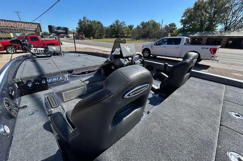 Slide: The Image of 2026 Phoenix 21 XE boat interior with dual seats and dashboard, parked near a road. - 8