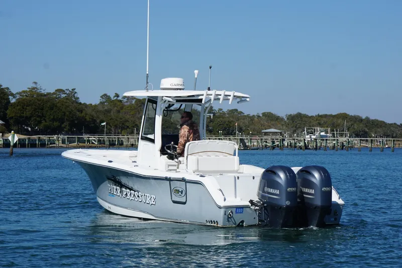 Slide: The Image of 2020 Sea Hunt Gamefish 27 boat with dual Yamaha engines on a calm waterway. - 1