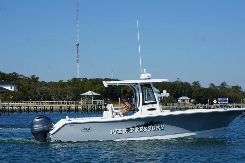 Slide: The Image of 2020 Sea Hunt Gamefish 27 boat cruising on water near a dock. - 5