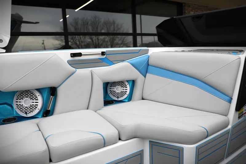 Slide: The Image of 2026 Centurion Nv233 boat interior with white and blue seating, featuring built-in speakers. - 11