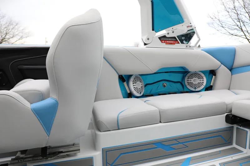 Slide: The Image of 2026 Centurion Nv233 boat interior with white and blue seating, featuring built-in speakers. - 12