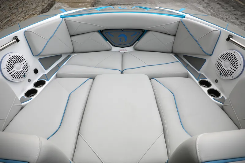 Slide: The Image of 2026 Centurion Nv233 boat interior with gray seating, blue accents, and built-in speakers. - 7