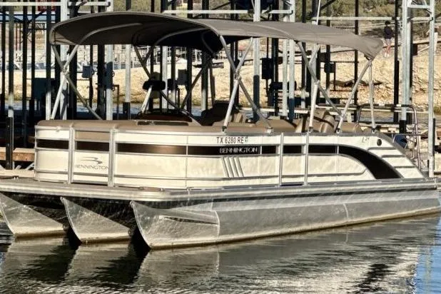 Slide: The Image of 2021 Bennington L 24 Swingback pontoon boat docked on calm water. - 0