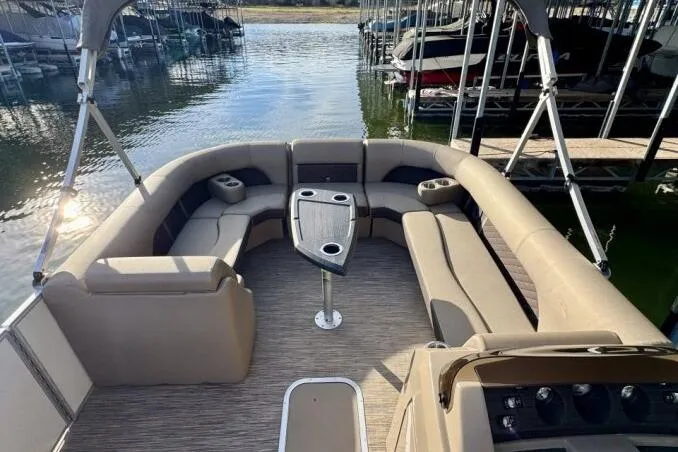 Slide: The Image of 2021 Bennington L 24 Swingback pontoon boat with spacious seating and table on a calm lake. - 11