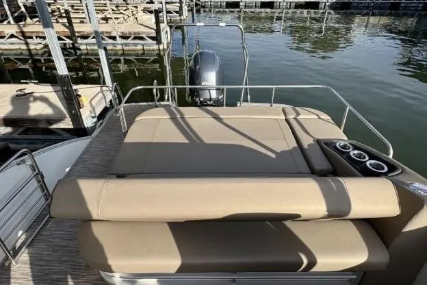 Slide: The Image of 2021 Bennington L 24 Swingback pontoon boat with spacious seating and cup holders at a dock. - 13