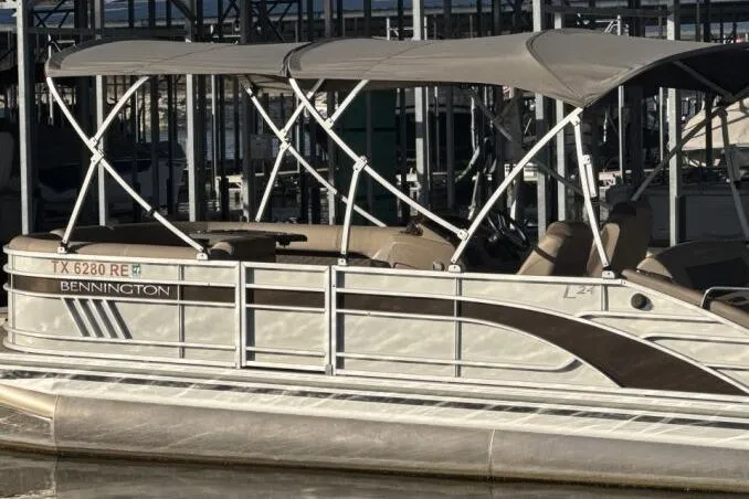 Slide: The Image of 2021 Bennington L 24 Swingback pontoon boat docked with canopy. - 24