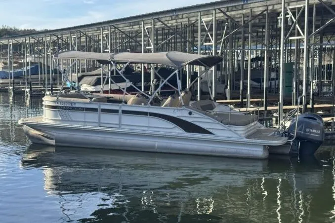 Slide: The Image of 2021 Bennington L 24 Swingback pontoon boat docked with Yamaha outboard motor. - 27