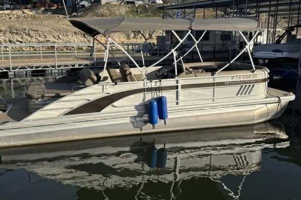 Slide: The Image of 2021 Bennington L 24 Swingback pontoon boat docked on calm water. - 30