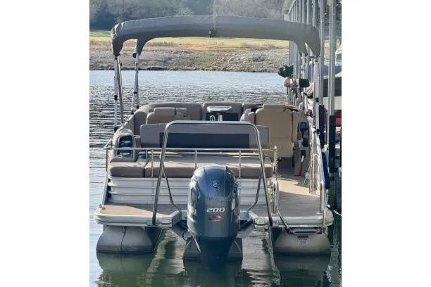 Slide: The Image of 2021 Bennington L 24 Swingback pontoon boat with 200 HP engine on a calm lake. - 31