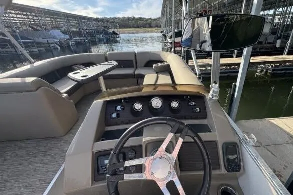 Slide: The Image of 2021 Bennington L 24 Swingback boat interior with steering wheel and seating area. - 4