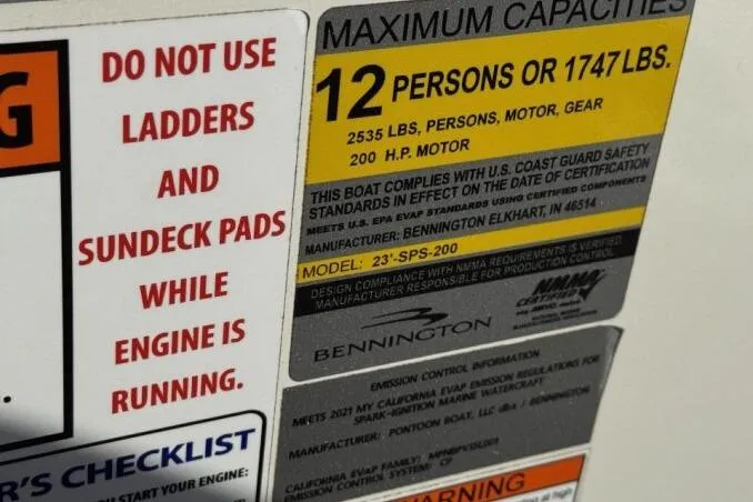 Slide: The Image of Bennington L 24 Swingback 2021 capacity label: 12 persons, 1747 lbs, 200 HP motor warning. - 9