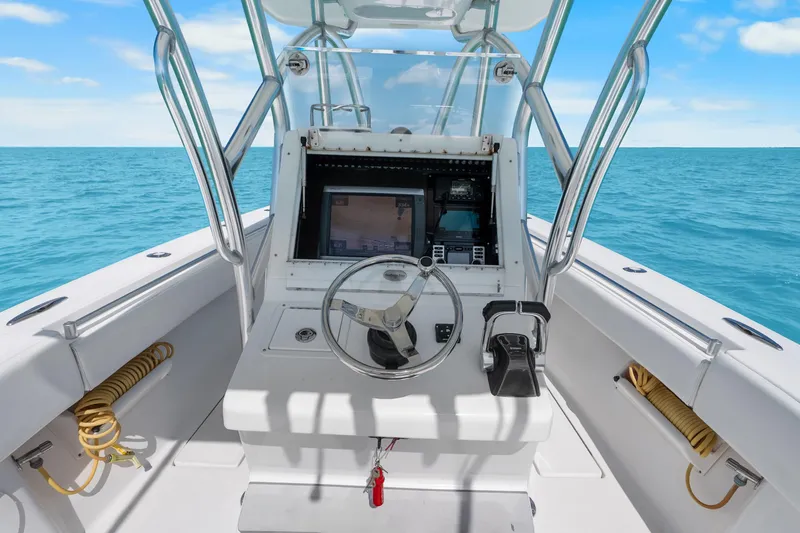 Slide: The Image of 2012 SeaHunter 29 boat cockpit with steering wheel and navigation system on open sea. - 22