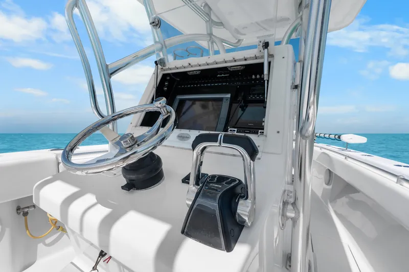 Slide: The Image of 2012 SeaHunter 29 boat helm with steering wheel and controls, ocean view. - 23