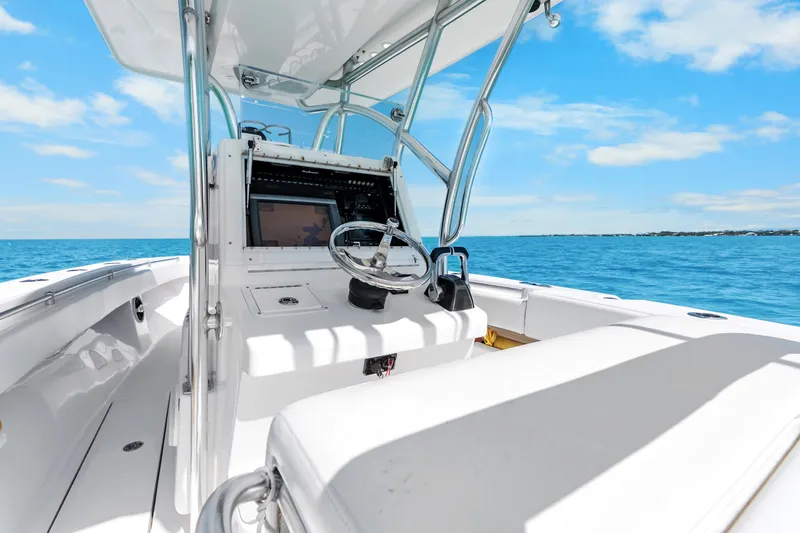 Slide: The Image of 2012 SeaHunter 29 boat interior with steering wheel, open sea view, and clear blue sky. - 24