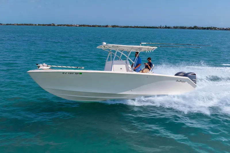 Slide: The Image of 2012 SeaHunter 29 boat cruising on clear blue water with two people onboard. - 4