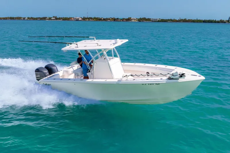 Slide: The Image of 2012 SeaHunter 29 boat cruising on clear blue water, featuring dual outboard engines. - 5
