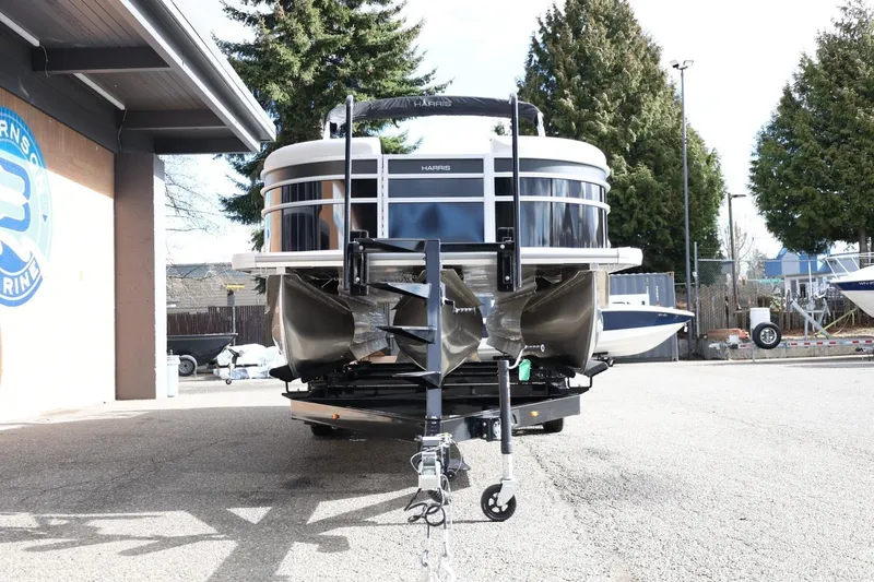 Slide: The Image of 2026 Harris Cruiser 210 SL pontoon boat on trailer, parked outdoors near a building. - 14