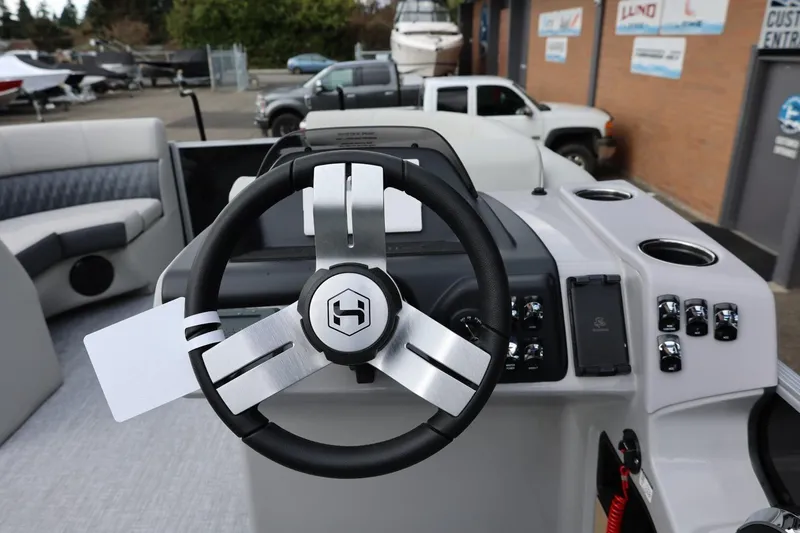 Slide: The Image of 2026 Harris Cruiser 210 SL boat dashboard with steering wheel and control panel. - 28