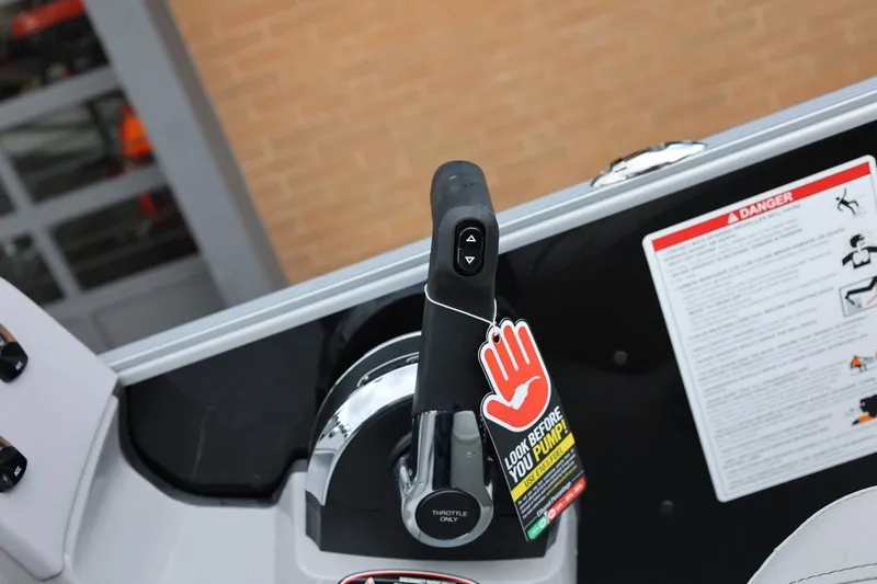Slide: The Image of Throttle control of 2026 Harris Cruiser 210 SL boat with safety warning tag. - 31