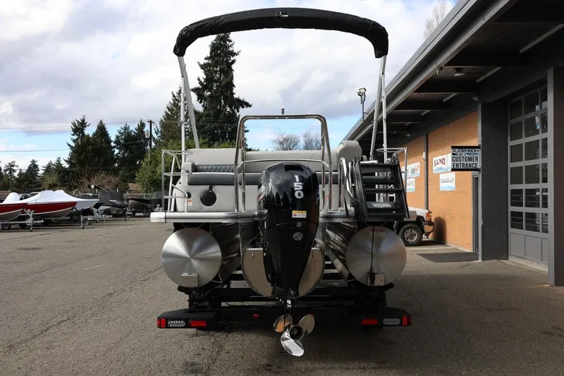Slide: The Image of 2026 Harris Cruiser 210 SL pontoon boat with outboard motor, parked outdoors. - 5
