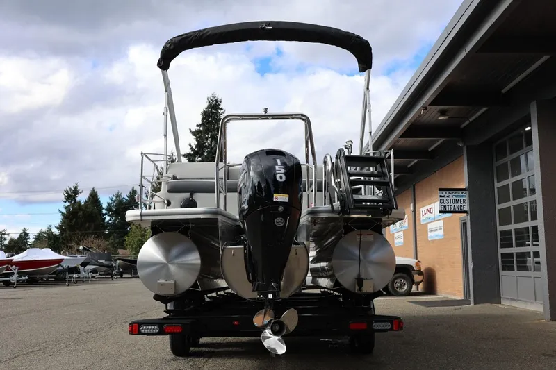 Slide: The Image of 2026 Harris Cruiser 210 SL pontoon boat with powerful outboard motor, parked outdoors. - 6