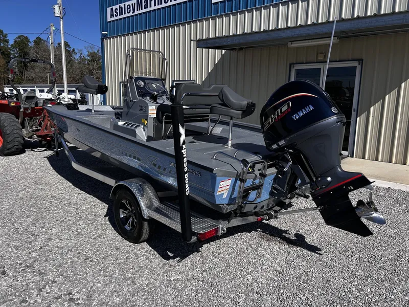 Slide: The Image of 2026 Xpress H20B Bay boat with Yamaha engine in front of a building. - 3