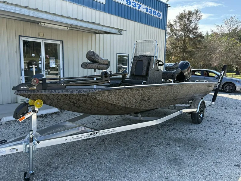 Slide: The Image of 2026 Xpress H20B Bay boat on trailer outside building. - 4