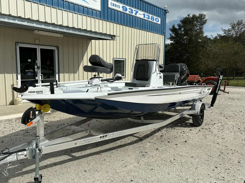Slide: The Image of 2026 Xpress H20B Bay boat on trailer outside building. - 3