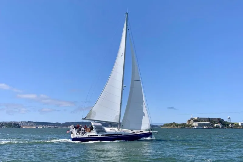 Slide: The Image of 2022 Beneteau Oceanis Yacht 54 sailing on open water under clear blue skies. - 1