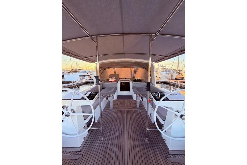 Slide: The Image of 2022 Beneteau Oceanis Yacht 54 cockpit with dual steering wheels and spacious seating. - 17