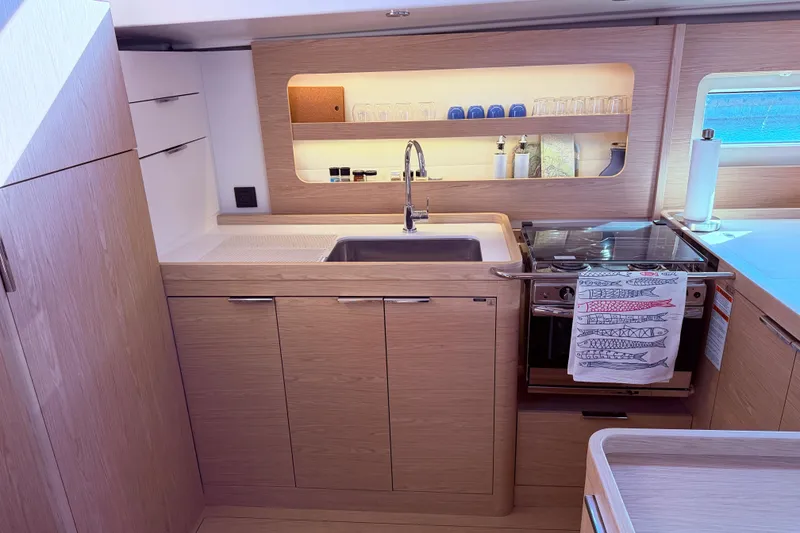 Slide: The Image of Modern kitchen in 2022 Beneteau Oceanis Yacht 54, featuring sleek wood cabinetry and stainless steel appliances. - 32