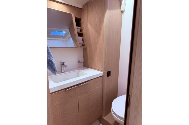 Slide: The Image of Modern bathroom in 2022 Beneteau Oceanis Yacht 54, featuring sleek wood cabinetry and fixtures. - 49