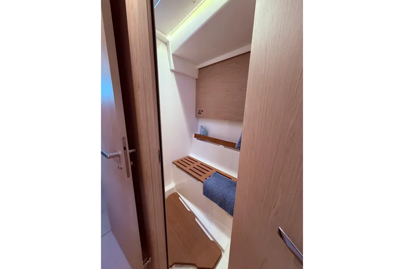 Slide: The Image of Interior of 2022 Beneteau Oceanis Yacht 54, featuring a sleek wooden bathroom design. - 50